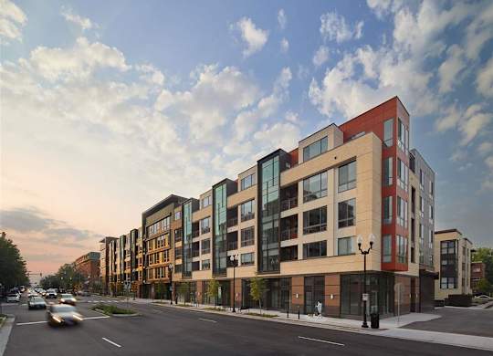 A modern apartment building with a mix of brick and glass facades.