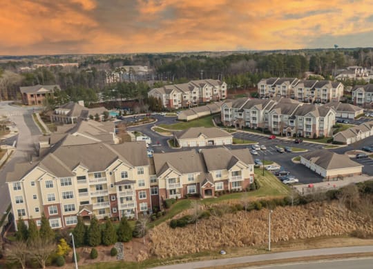 an aerial view of a large housing complex with a sunset in the background