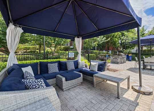 a patio with couches and umbrellas and tables at Tradition at Stonewater, North Carolina