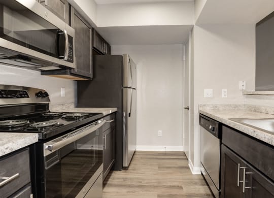 Kitchen with stainless steel appliances and dark cabinets at Elme Herndon, Herndon, VA