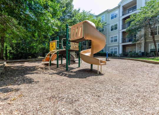 a playground with a slide and other playground equipment in a park