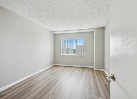 A room with a window and wooden flooring.
