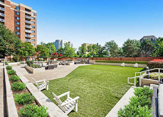 A well-maintained outdoor area with a grassy field, benches, and a fence at Cascade at Landmark, Virginia