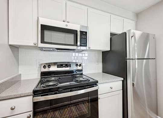 A kitchen with a black refrigerator and a black and silver stove  at Cascade at Landmark, Virginia