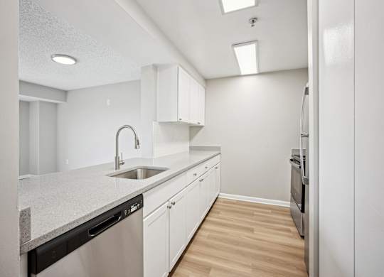 A modern kitchen with white cabinets and a granite countertop.