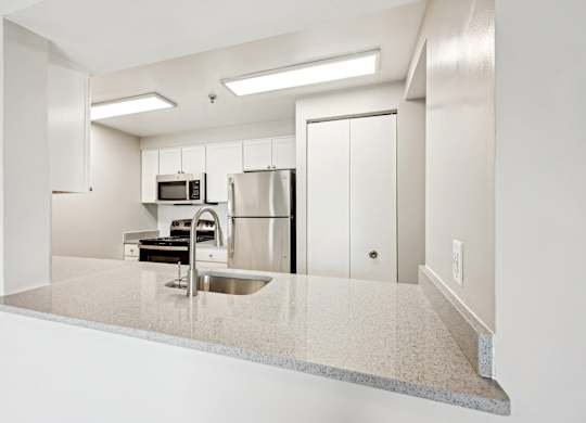 A kitchen with a sink, microwave, and refrigerator at Cascade at Landmark, Virginia