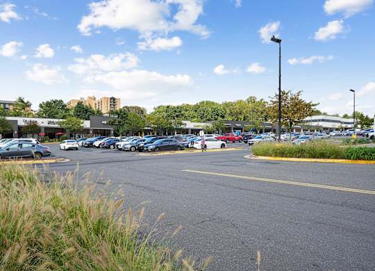 A parking lot with cars and a building in the background.