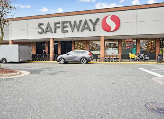 A Safeway store with a car parked in front.