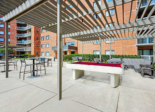 A patio with a table and chairs under a roof at Cascade at Landmark, Virginia