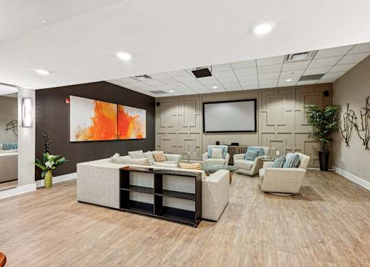 A living room with a large painting on the wall and a TV above the couch.