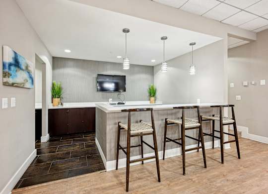 A bar area with a TV and two chairs at Cascade at Landmark, Virginia