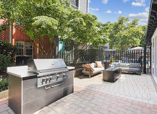 A backyard with a grill and a couch.