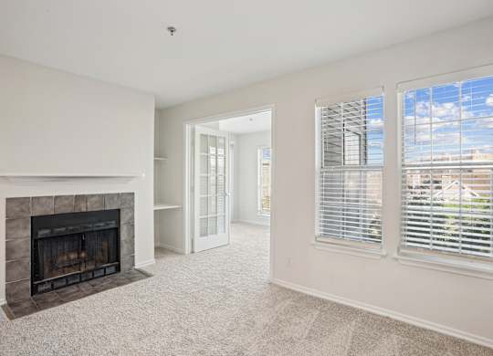 A living room with a fireplace and a carpeted floor.