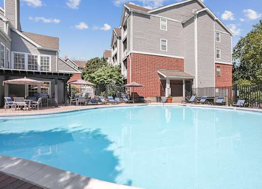 A swimming pool in front of a building with a red brick exterior at Elme Alexandria, Alexandria, 22304