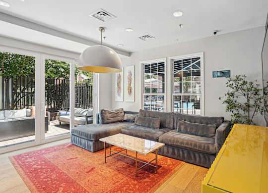 A living room with a grey couch and a yellow coffee table.