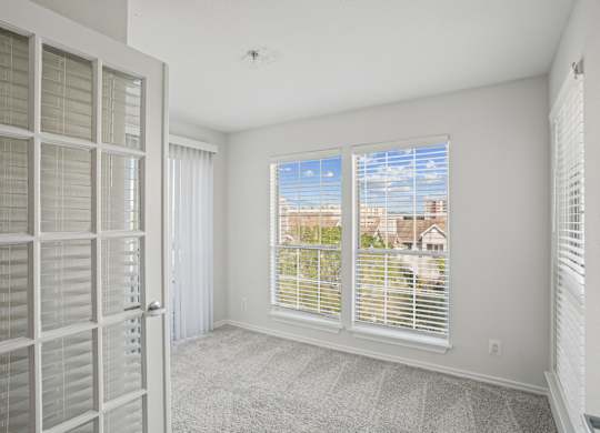 A room with a view of the outside through the window.