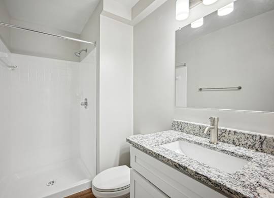 A white bathroom with a marble countertop and a toilet at Elme Bethesda, Bethesda, 20814
