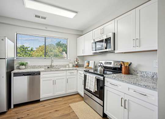 A kitchen with white cabinets and stainless steel appliances at Elme Bethesda, Bethesda, 20814