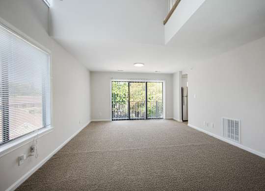 A spacious room with a carpeted floor and a sliding glass door leading to a balcony at Elme Bethesda, Bethesda, 20814