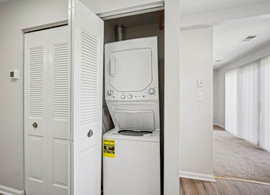 A white washing machine is in a small alcove in a room at Elme Bethesda, Bethesda, 20814