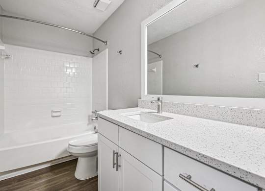 A white bathroom with a toilet, sink, and tub.
