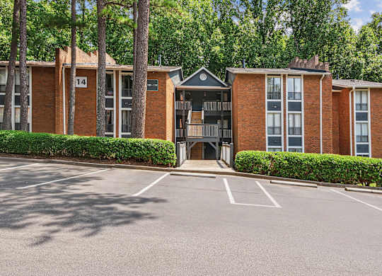A parking lot in front of a red brick building with the number 14 on it.