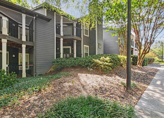 A building with a grey facade and a green tree in front at Elme Druid Hills, Atlanta, Georgia