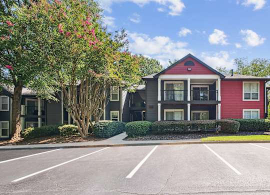 A red and grey building with a parking lot in front at Elme Druid Hills, Atlanta, Georgia
