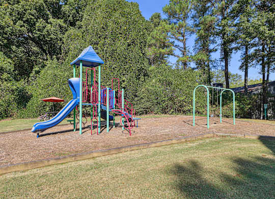 A playground with a blue slide and a red and blue climbing frame at Elme Druid Hills, Atlanta, Georgia