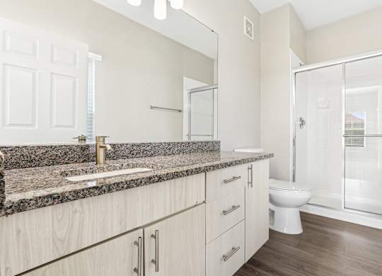 A bathroom with a granite countertop and a walk-in shower at Elme Dulles, Herndon, VA