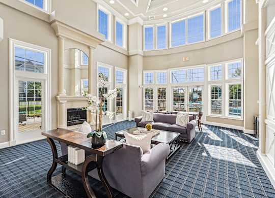 A large room with a fireplace and a table with chairs at Elme Dulles, Herndon, VA