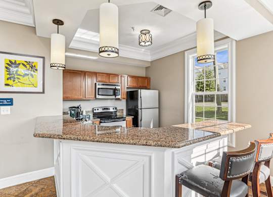 A kitchen with a granite countertop and a fridge at Elme Dulles, Herndon, VA