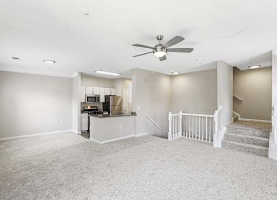 A spacious living room with a staircase leading to the upper floor.