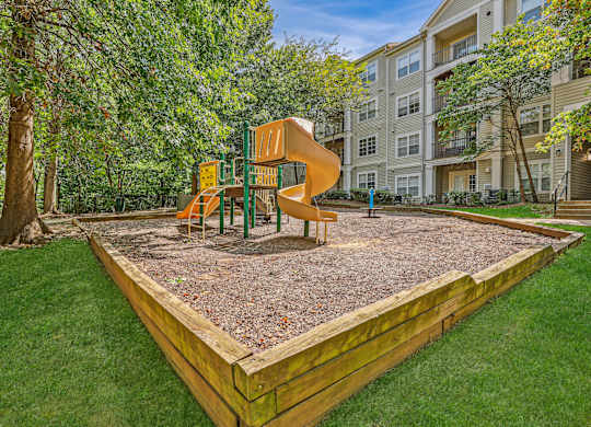 A playground with a slide and a wooden fence in the foregroundat Elme Dulles, Herndon, VA