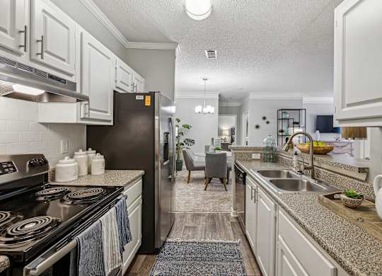 A kitchen with a black stove top oven and white cabinets.