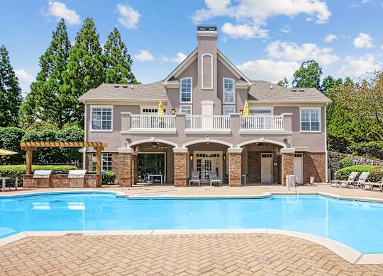 A large house with a pool in front.