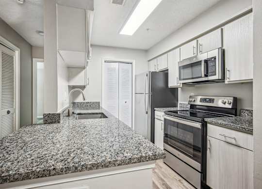 A kitchen with granite countertops and stainless steel appliances.