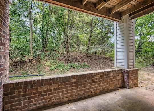 A view from a porch looking out to a wooded area.