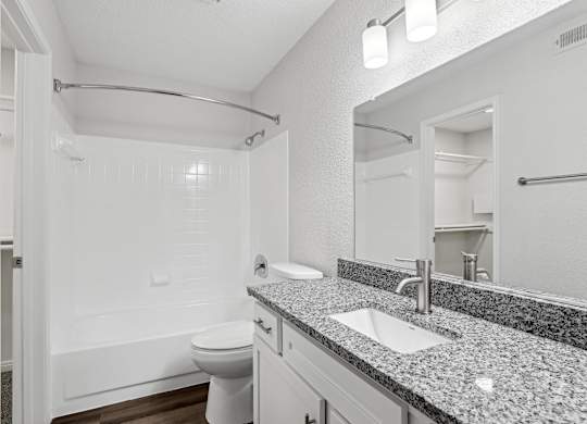 A bathroom with a white toilet, sink, and bathtub.