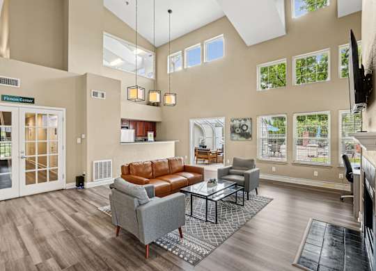 A living room with a brown couch and a grey armchair.