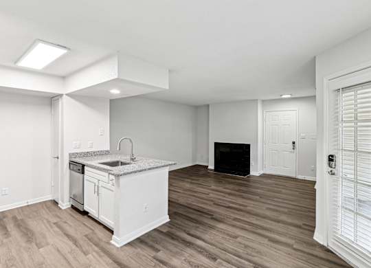 A kitchen with a sink, stove, and cabinets.