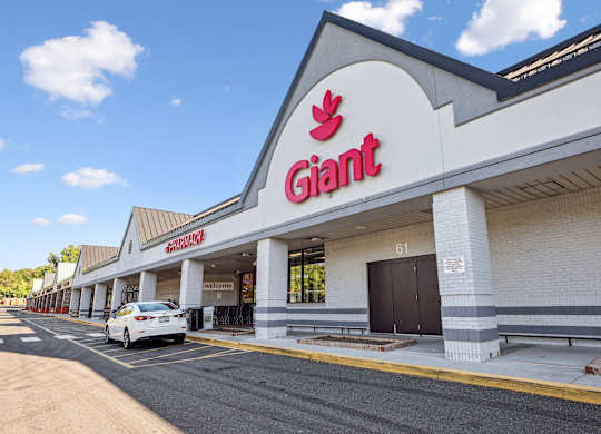 A Giant supermarket storefront with a white car parked in front.