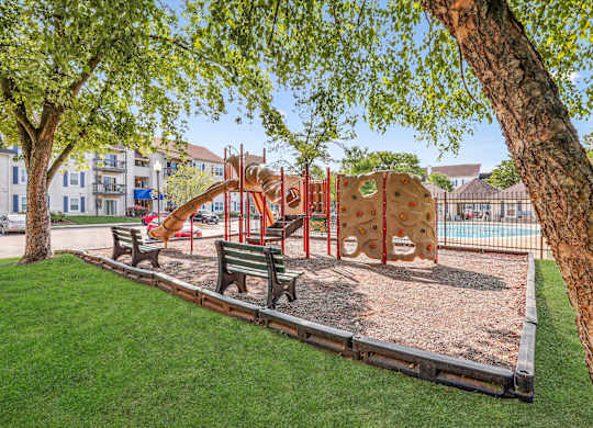 A playground with a slide, swings, and a sandbox.
