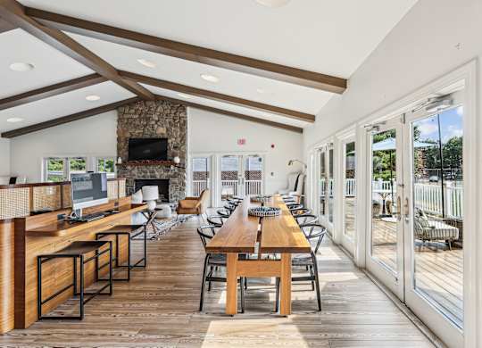A modern dining room with a stone fireplace and wooden floors at Elme Manassas, Manassas, 20109