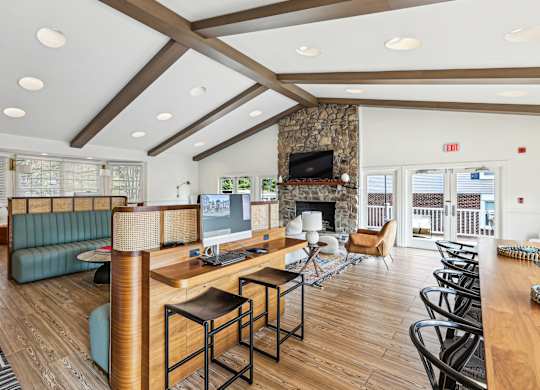 A living room with a stone fireplace and a large window.