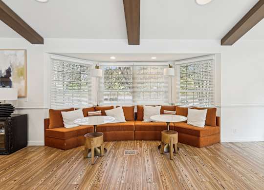 A living room with a large orange couch and wooden floors at Elme Manassas, Manassas, 20109