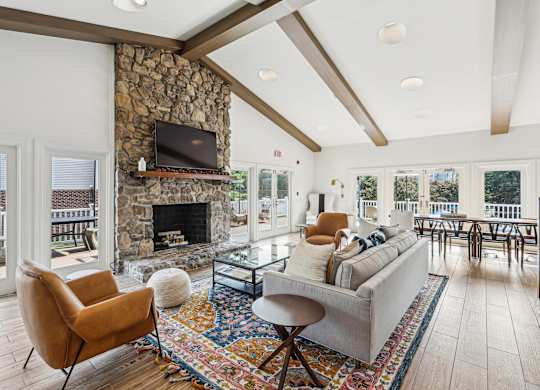 A living room with a stone fireplace and a television above it at Elme Manassas, Manassas, 20109