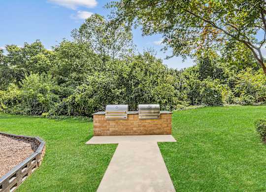 A backyard with a hot tub and a concrete walkway.