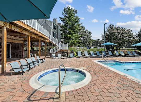 A pool surrounded by chairs and umbrellas at Elme Manassas, Manassas, 20109