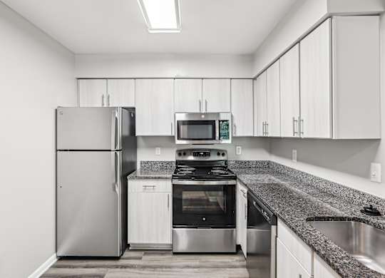 A modern kitchen with a stainless steel refrigerator, oven, and microwave at Elme Manassas, Manassas, 20109